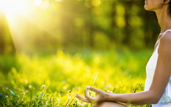 Yoga woman meditating at sunset Wellness Origin